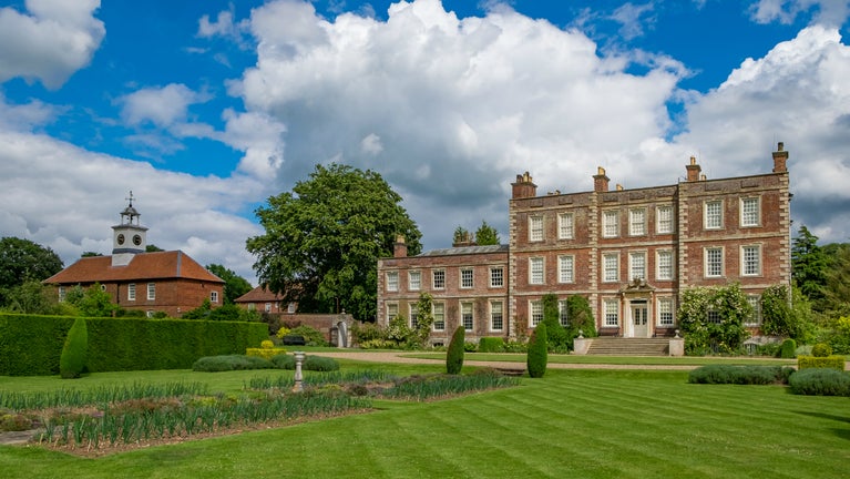 The red-brick front of Gunby Hall with the manicured lawns in the foreground